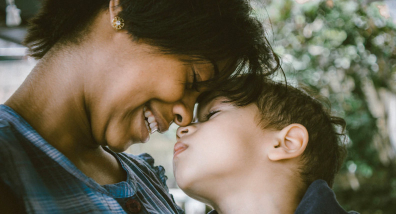 Black woman nuzzling her white son